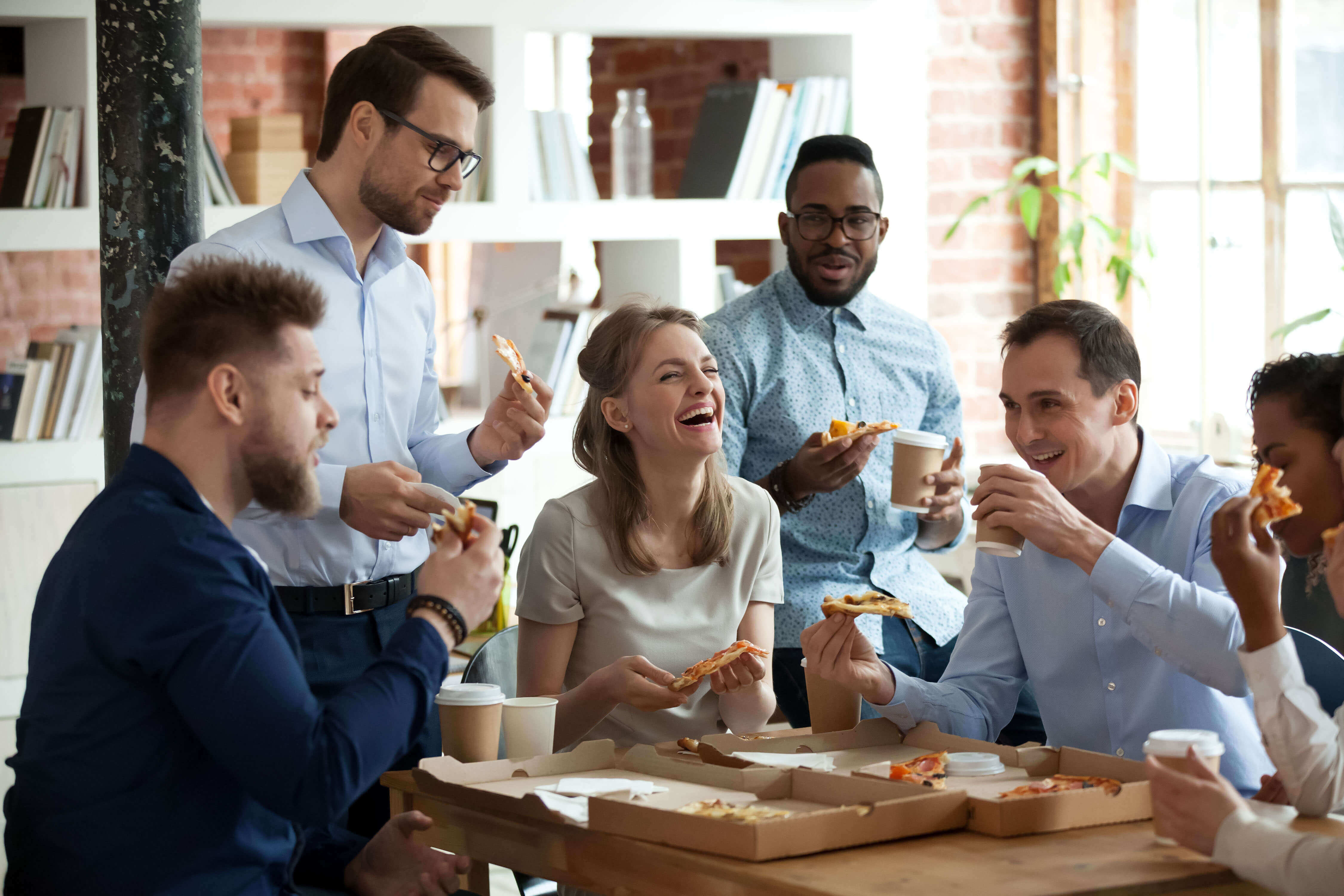 People in an office laughing on their lunch break 