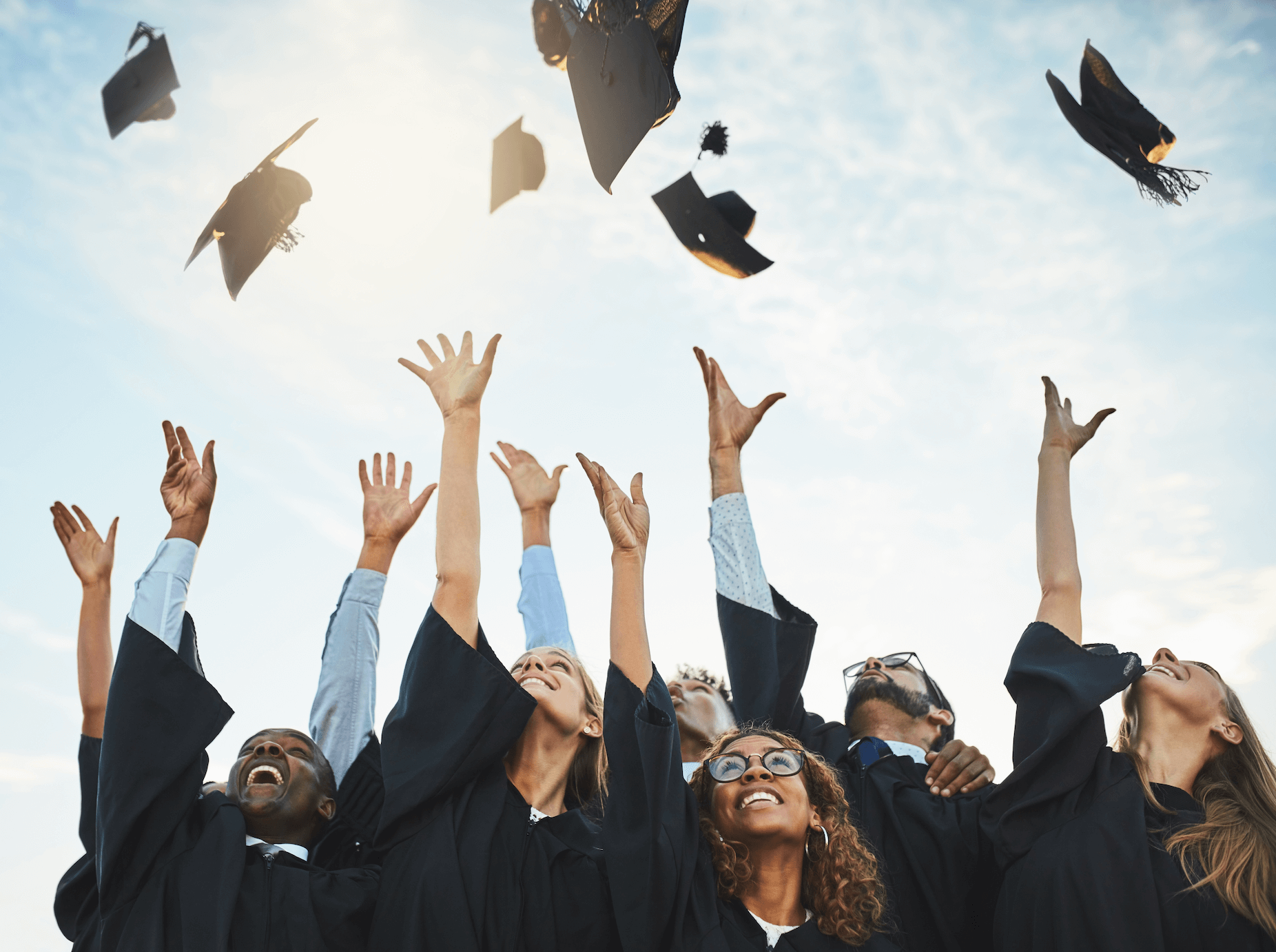 Graduating students throwing mortarboard hats in the air