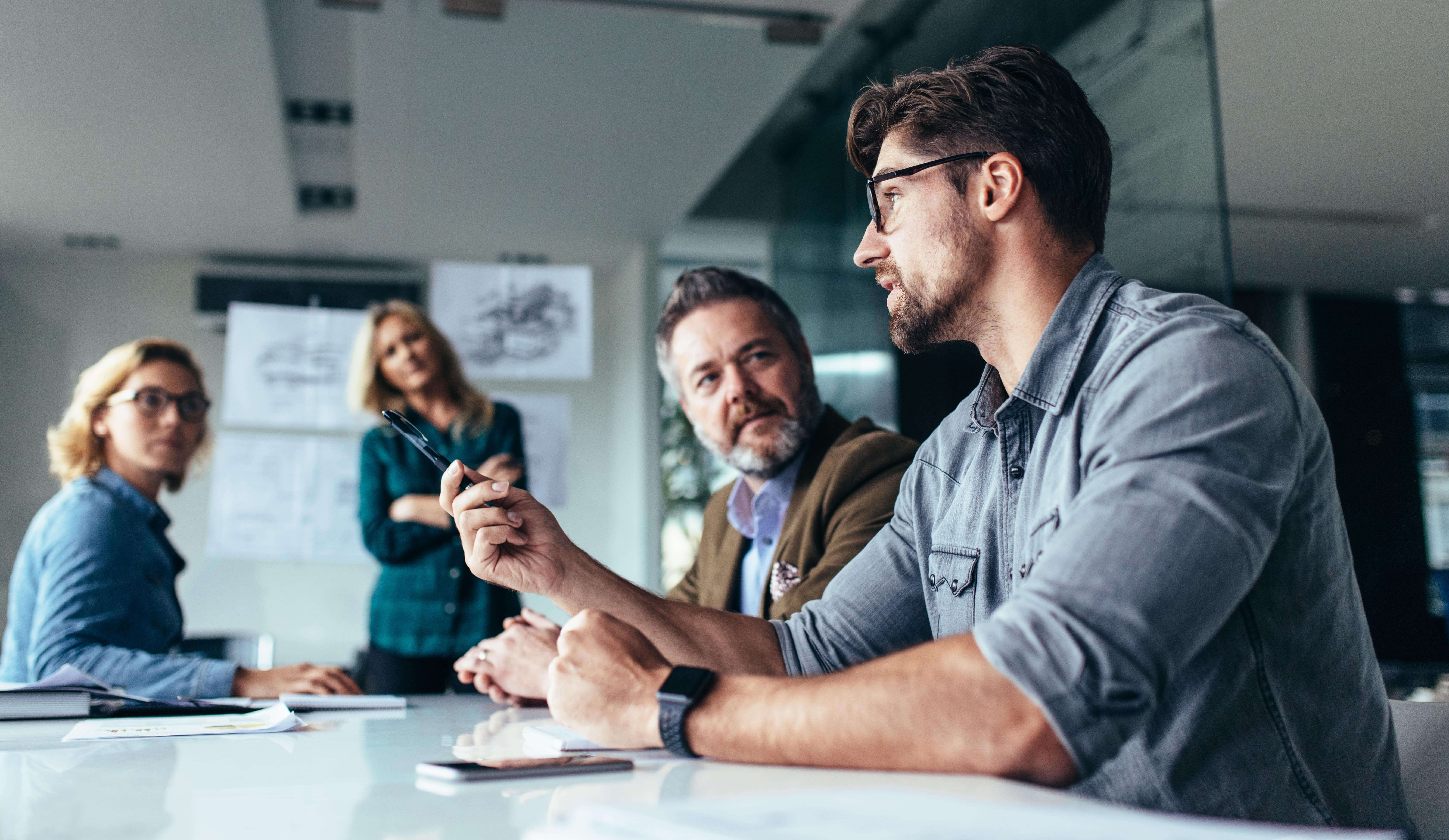 Employees talking sat at a meeting table