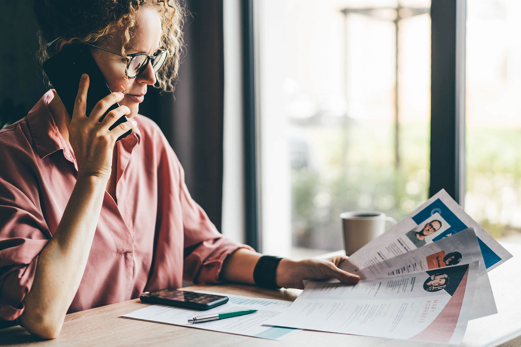 Young woman sat at a desk on her phone 