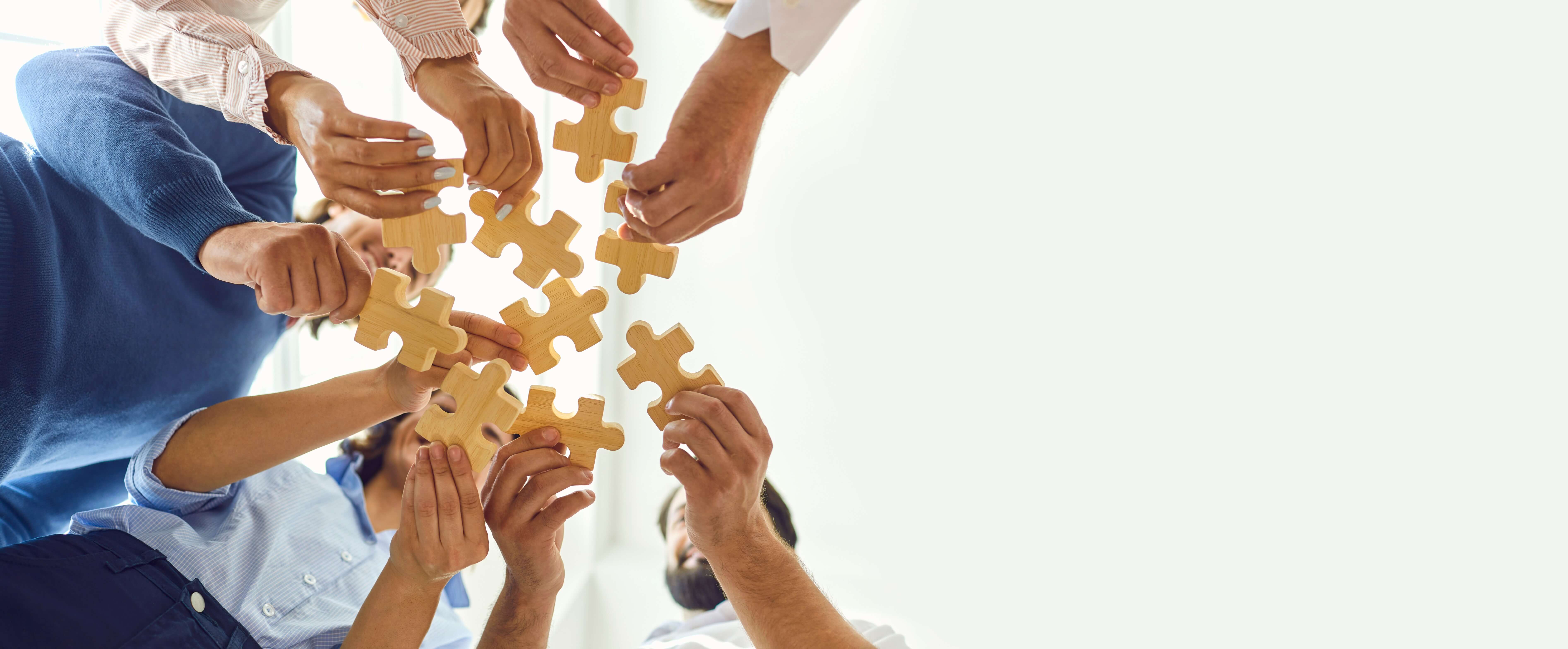 Several people holding jigsaw pieces